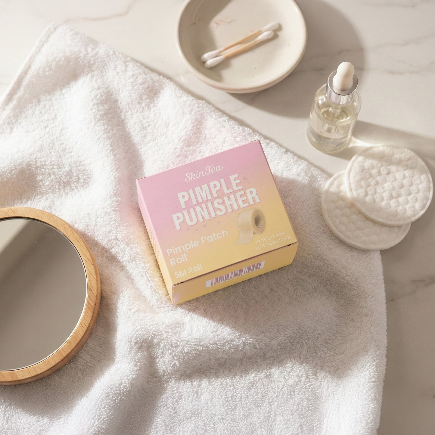 Pink and yellow box labeled 'Pimple Punisher' on a white towel with skincare items.